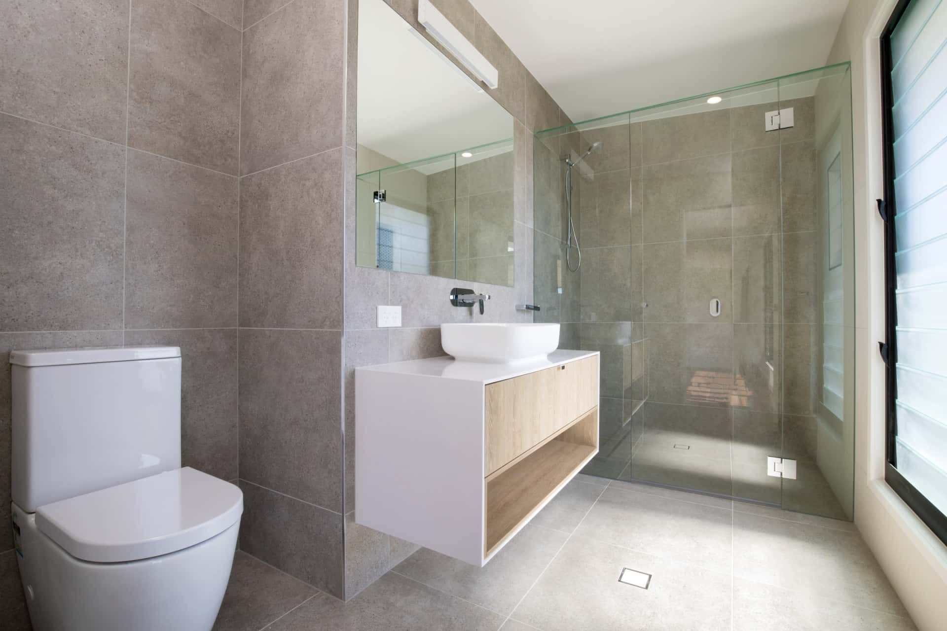 Modern Bathroom with Gray Tiled Walls and Floors — Frameless Shower Installations In Maroochydore, QLD