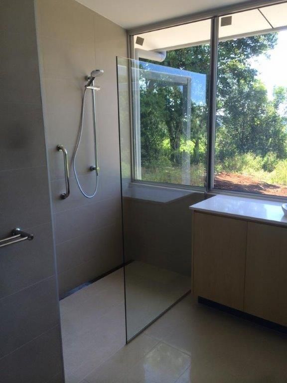 A Bathroom With A Walk In Shower And A Large Window — Frameless Shower Installations In Maroochydore, QLD