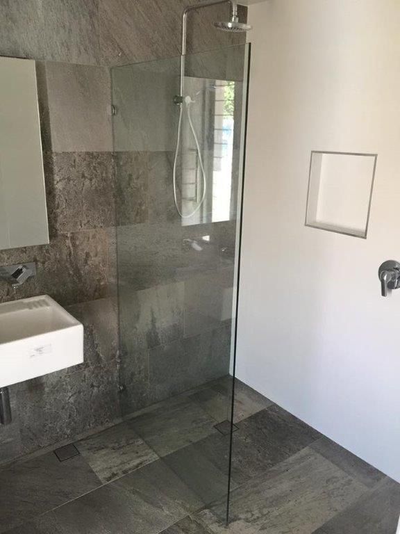 A Modern Staircase With Wooden Steps and a Glass Railing — Frameless Shower Installations In Maroochydore, QLD 