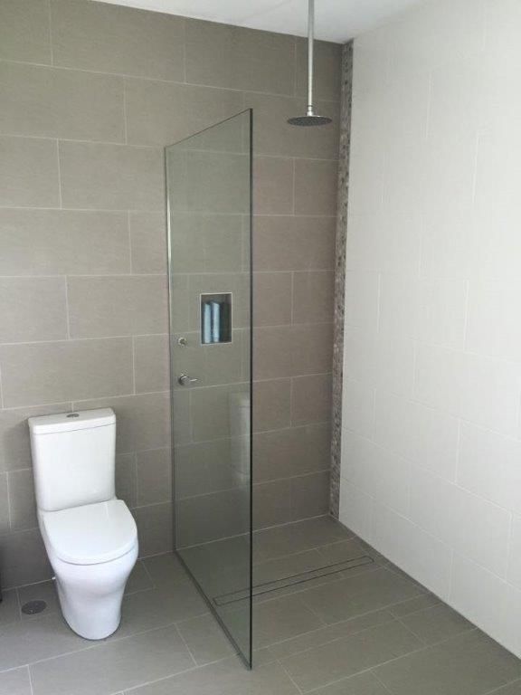 A Bathroom With A Toilet And A Walk In Shower — Frameless Shower Installations In Maroochydore, QLD