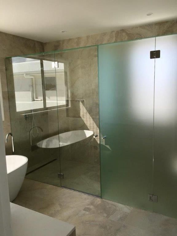 A Bathroom With A Bathtub And A Glass Shower Door — Frameless Shower Installations In Maroochydore, QLD