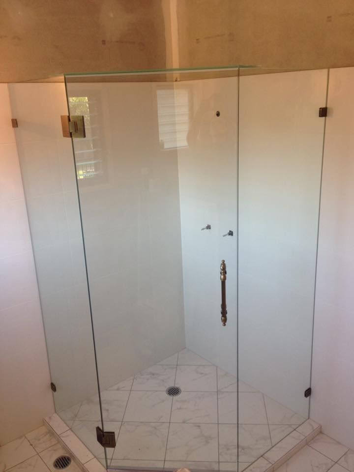 A Bathroom With a Glass Shower Door and a Tiled Floor — Frameless Shower Installations In Maroochydore, QLD 