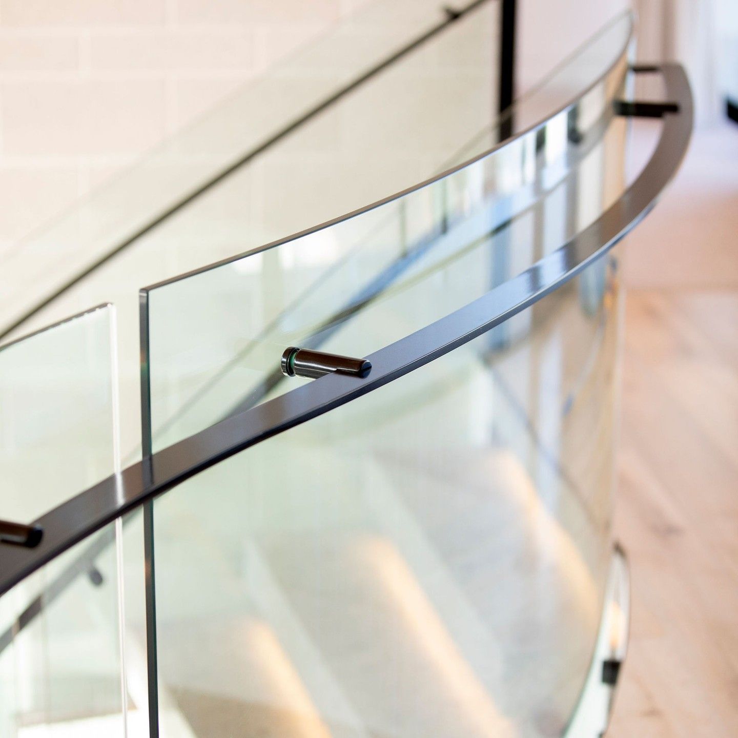 Curved Glass Railing With Black Metal Handrail, Indoors — Frameless Shower Installations In Maroochydore, QLD