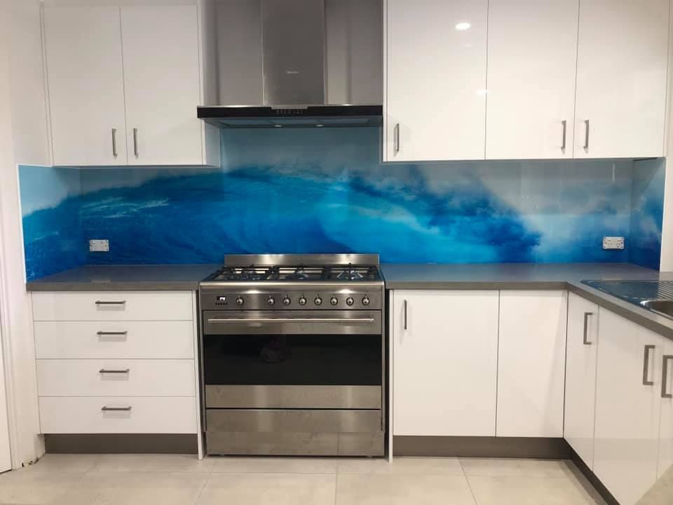 A Kitchen With White Cabinets , A Stove And A Sink — Frameless Shower Installations In Caloundra, QLD