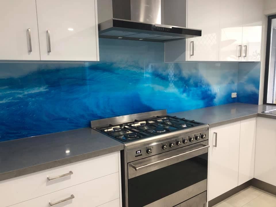 A Kitchen With A Stove , Oven , Cabinets And A Painting On The Wall — Frameless Shower Installations In Maroochydore, QLD