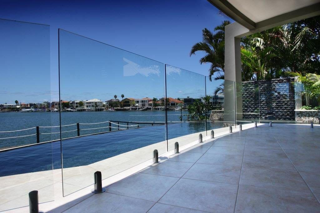 A Balcony With A Glass Railing Overlooking A Body Of Water — Frameless Shower Installations In Maroochydore, QLD
