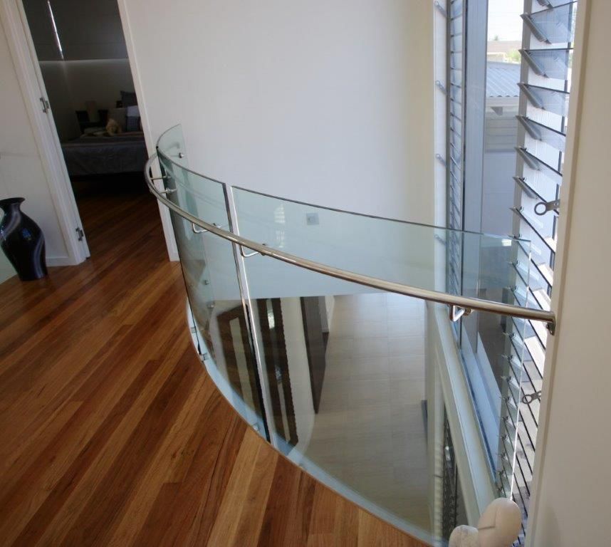 A Spiral Staircase With A Curved Glass Railing — Frameless Shower Installations In Maroochydore, QLD