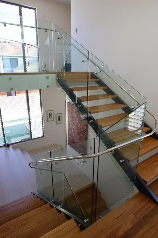 A Staircase With A Glass Railing And Wooden Steps — Frameless Shower Installations In Maroochydore, QLD