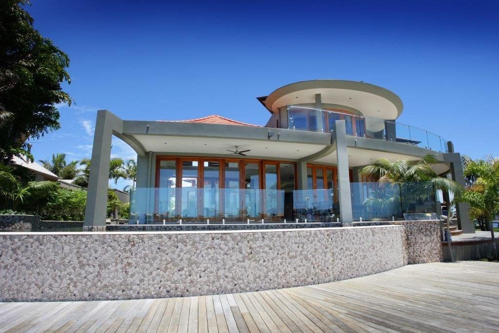 A Large House With A Lot Of Windows Is Surrounded By Trees — Frameless Shower Installations In Maroochydore, QLD