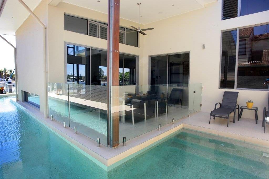 A Large Swimming Pool In The Backyard Of A House — Frameless Shower Installations In Maroochydore, QLD