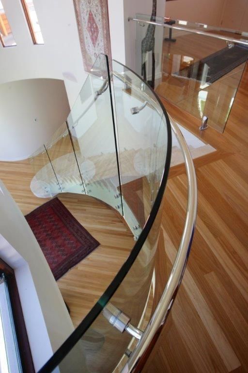 A Spiral Staircase With A Curved Glass Railing — Frameless Shower Installations In Maroochydore, QLD