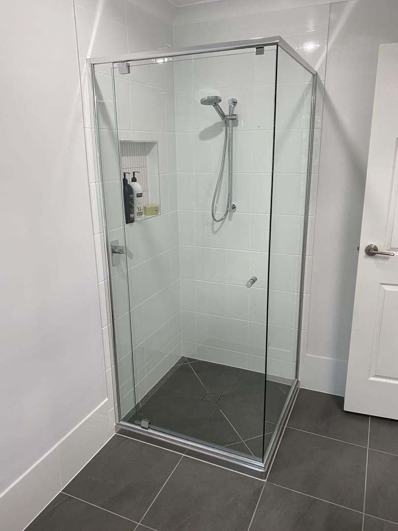 A Glass Shower Enclosure in A Modern Bathroom, with A Silver Frame, Tiled Walls, and Gray Floor — Frameless Shower Installations In Caloundra, QLD