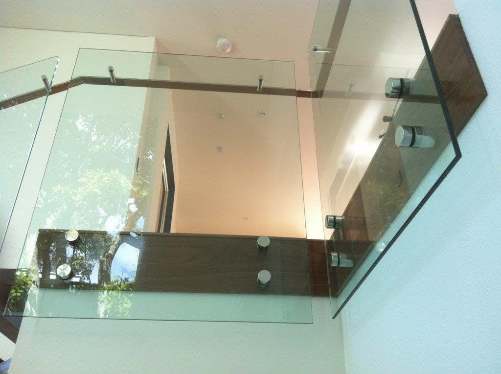 A Staircase With A Glass Railing And A Wooden Handrail — Frameless Shower Installations In Maroochydore, QLD
