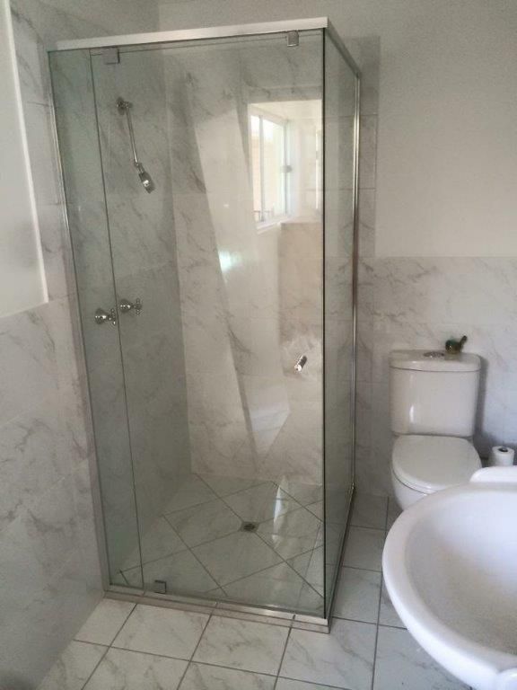 A Bathroom With A Toilet , Sink And Shower Stall — Frameless Shower Installations In Maroochydore, QLD