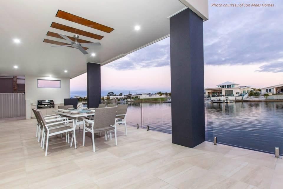 A Patio With A Table And Chairs Overlooking A Body Of Water — Frameless Shower Installations In Maroochydore, QLD