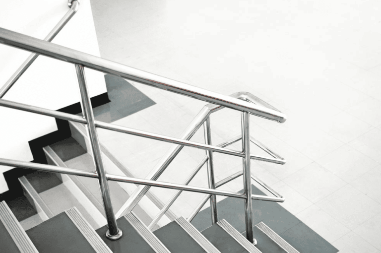 A Close Up Of A Staircase With A Metal Railing — Frameless Shower Installations In Maroochydore, QLD