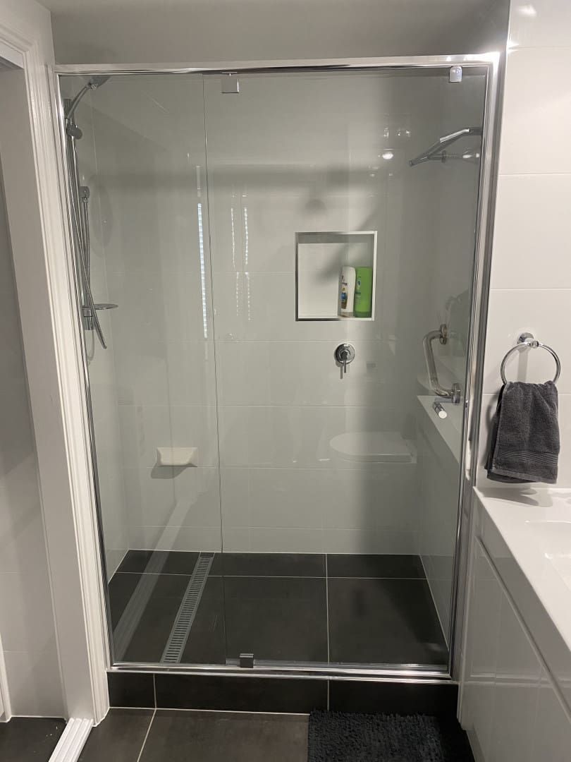 Modern Shower Stall with Glass Doors, Gray Walls, and Dark Tiled Floor — Frameless Shower Installations In Caloundra, QLD