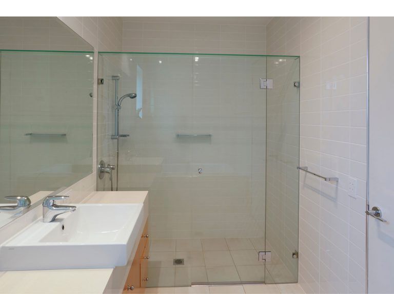A Bathroom With Two Sinks And A Glass Shower Door — Frameless Shower Installations In Maroochydore, QLD