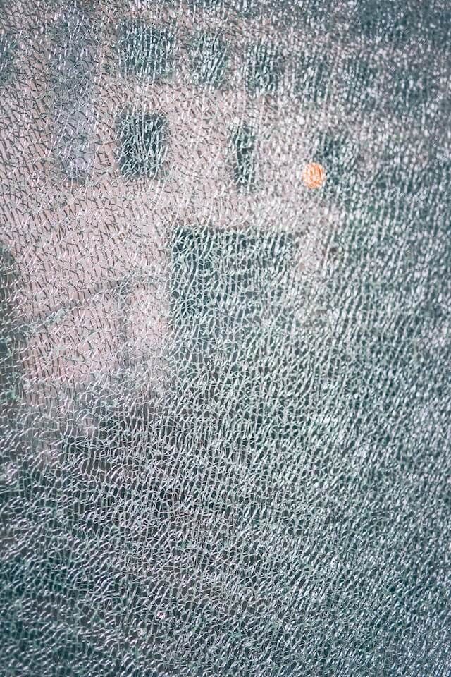 A Close Up Of A Cracked Glass Panel — Frameless Shower Installations In Maroochydore, QLD