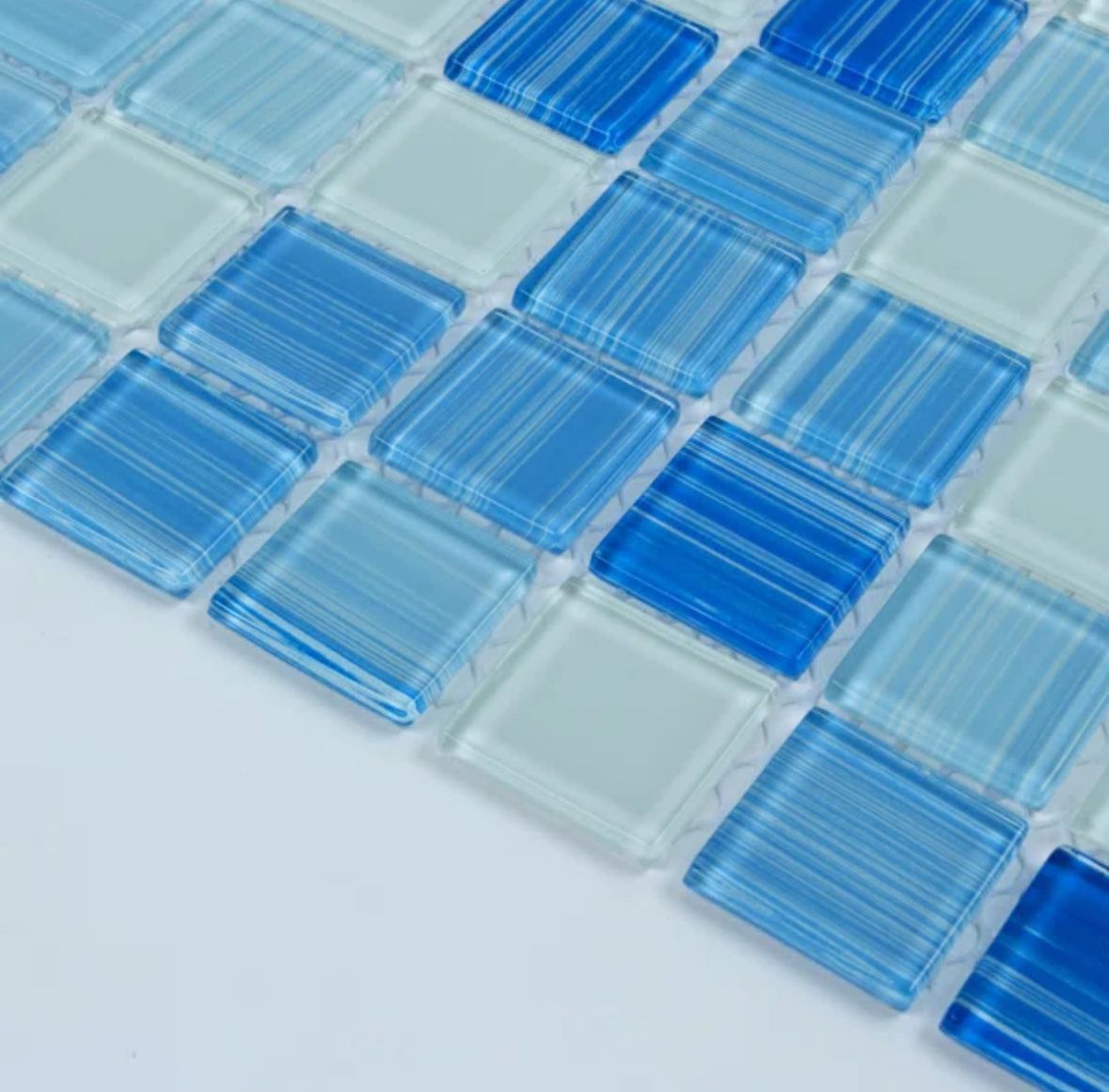 Blue and white glass mosaic tiles arranged in a grid pattern; close-up view.