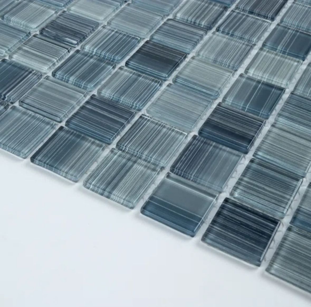 Blue glass mosaic tile close-up. Squares arranged in a grid with varying shades.