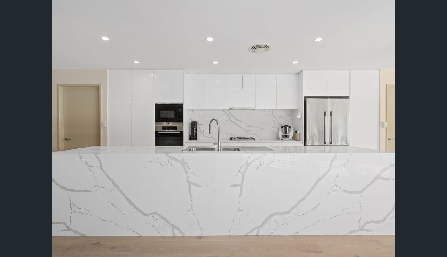 A Kitchen with White Cabinets and Marble Counter Tops — Sheridan Stone Aust in Toormina, NSW