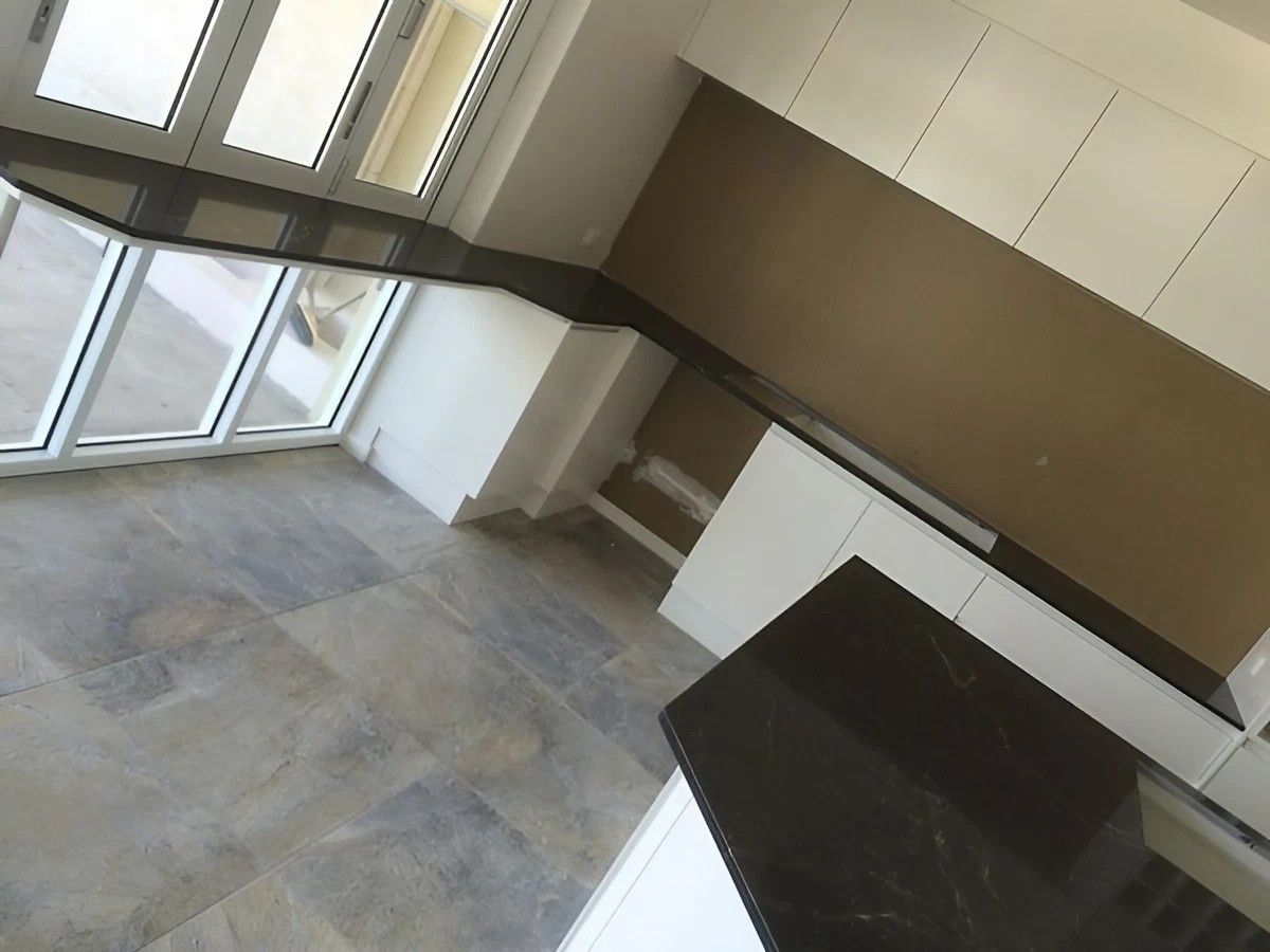 A Kitchen with A Black Counter Top and White Cabinets — Sheridan Stone Aust in Coffs Harbour, NSW