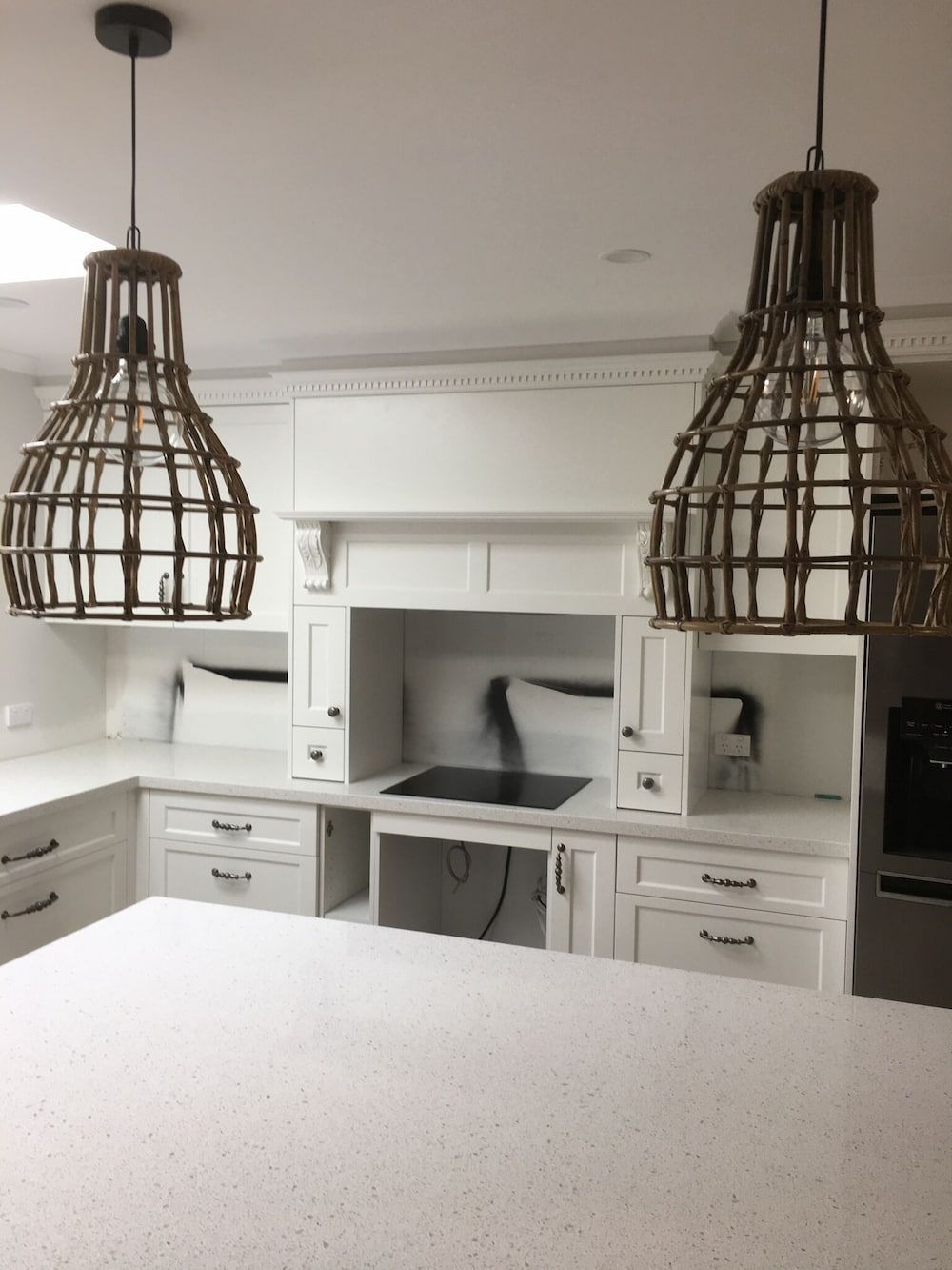 A Kitchen with Two Wicker Lamps Hanging from The Ceiling — Sheridan Stone Aust in Port Macquarie, NSW