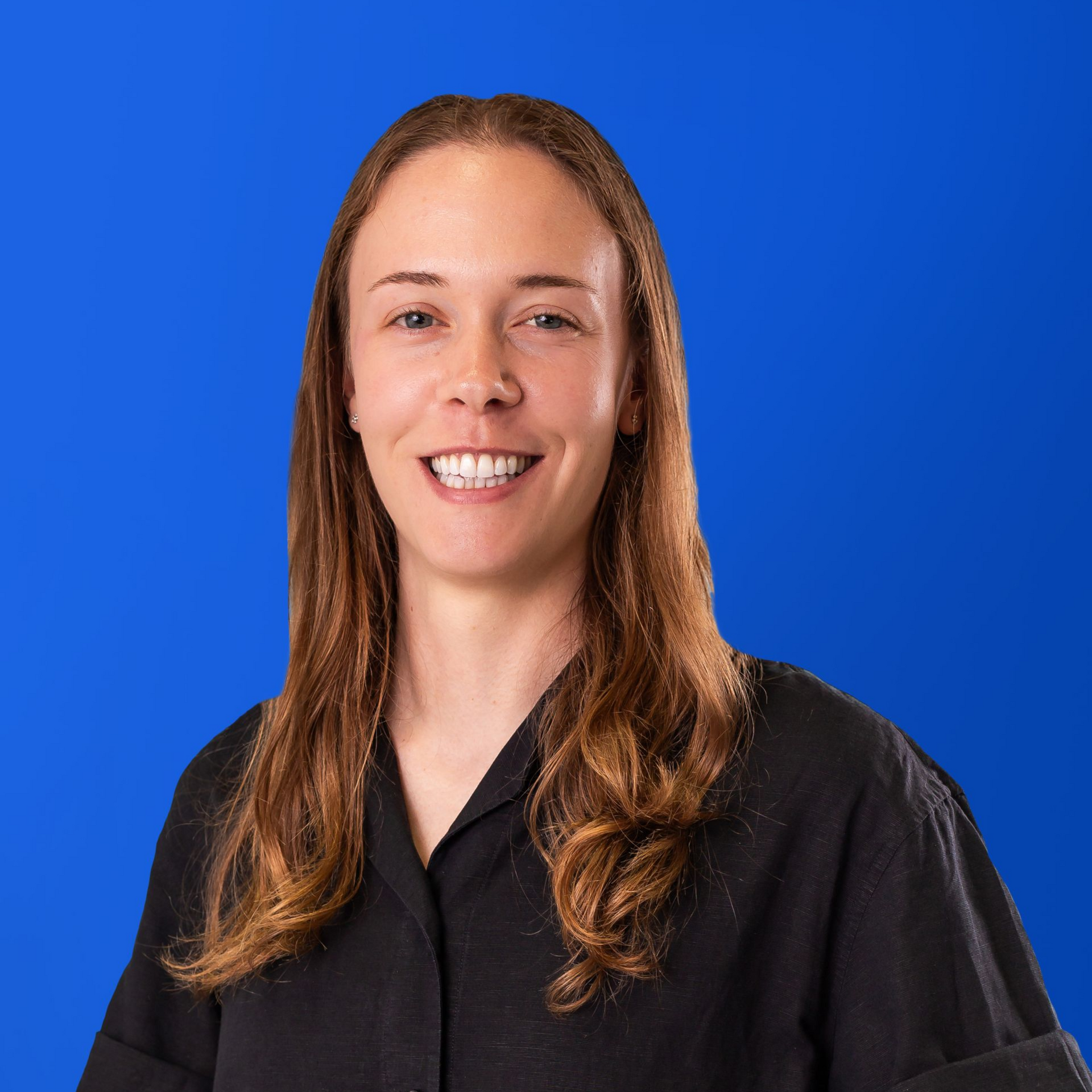 A woman with long red hair is smiling in a yellow circle.