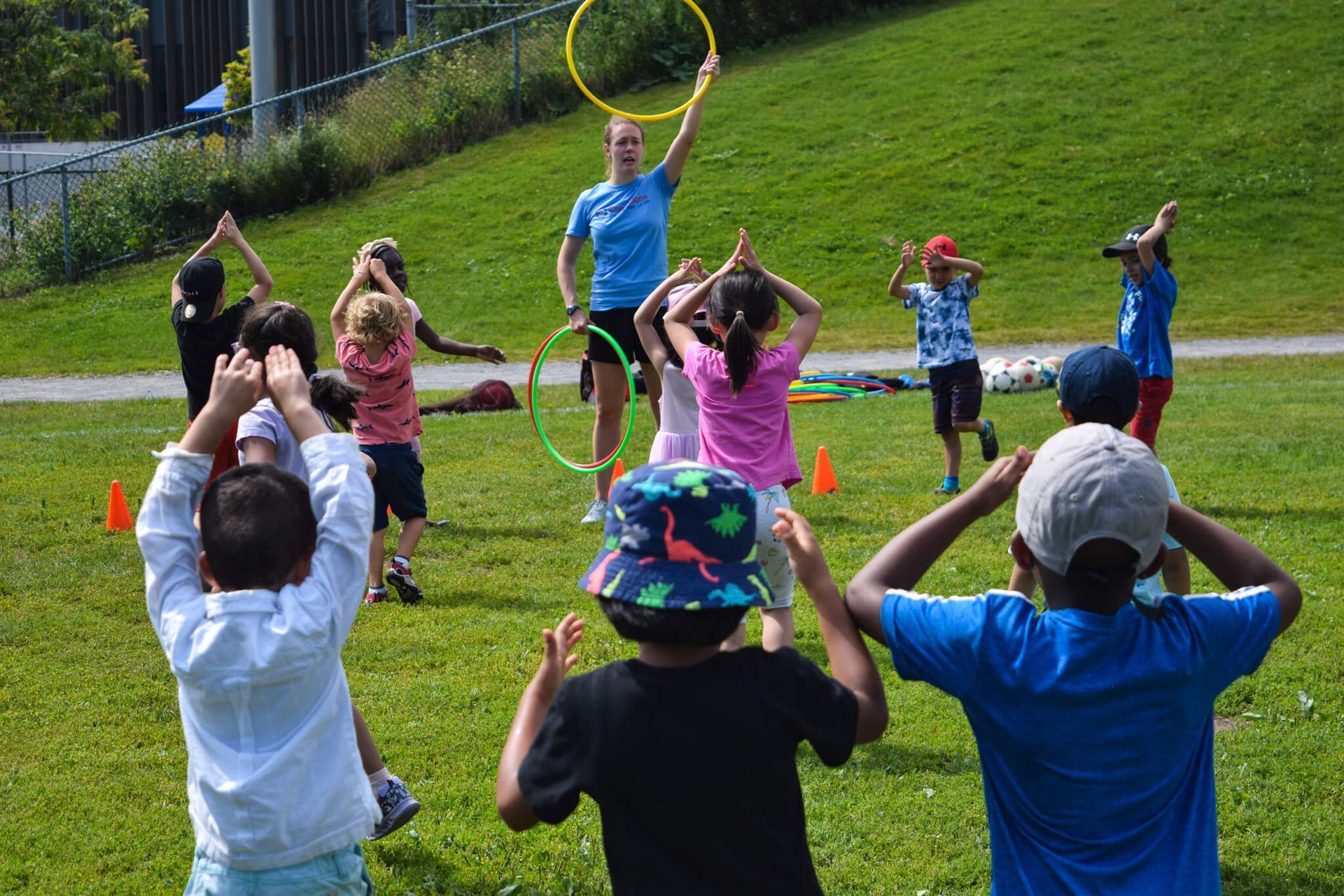 A group of children are playing with hula hoops in a park.
