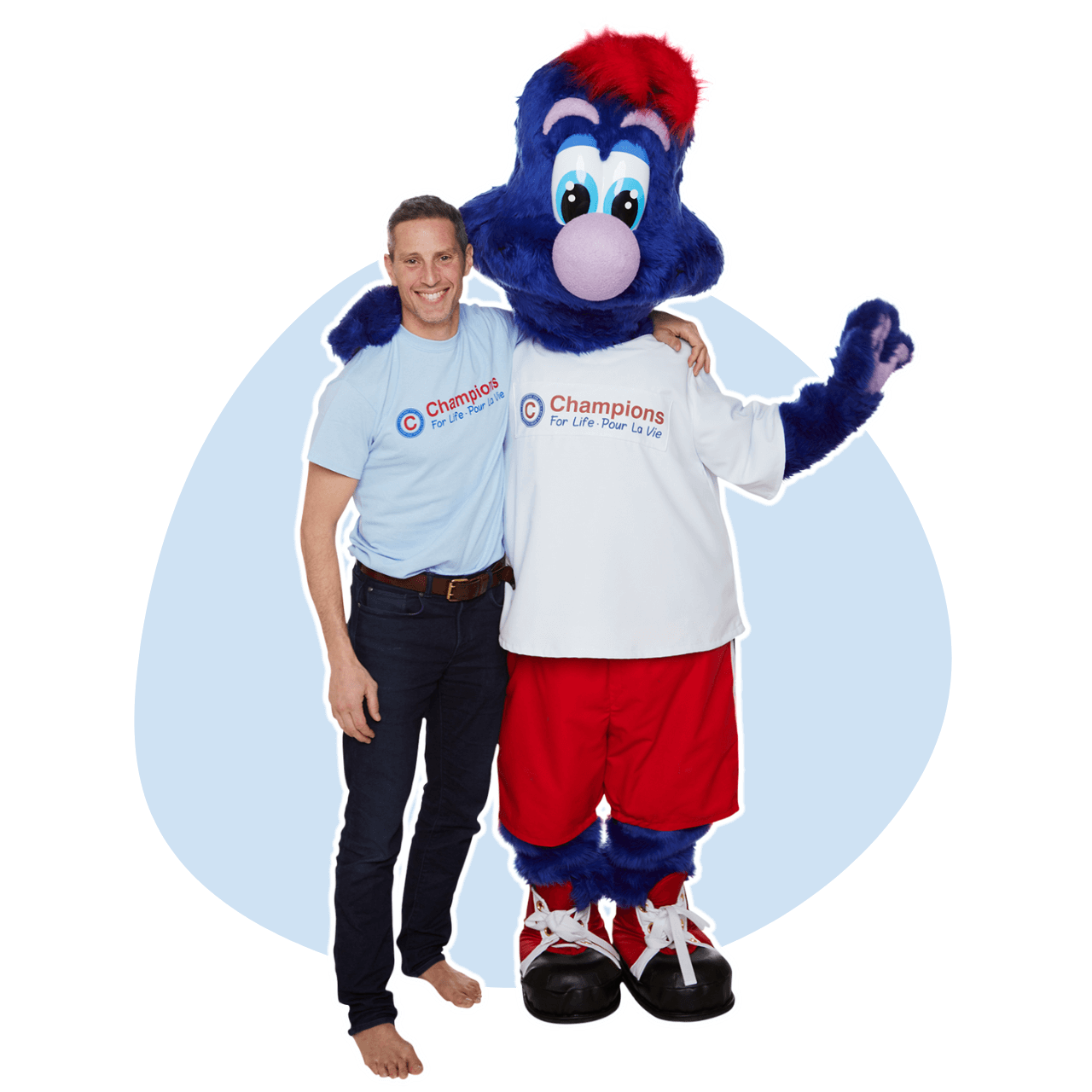 A man standing next to a mascot wearing a champions for life shirt