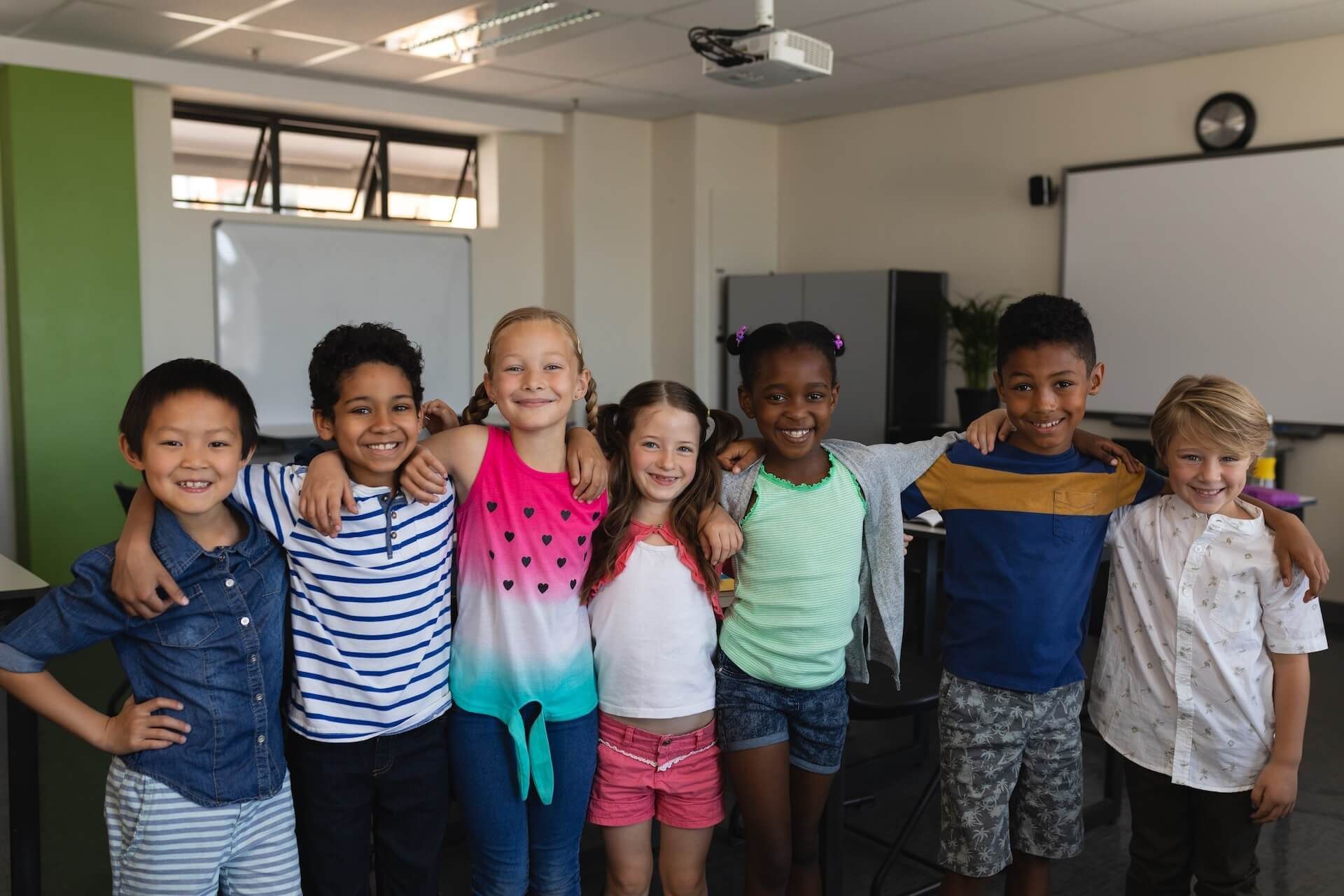A group of children are posing for a picture in a classroom.