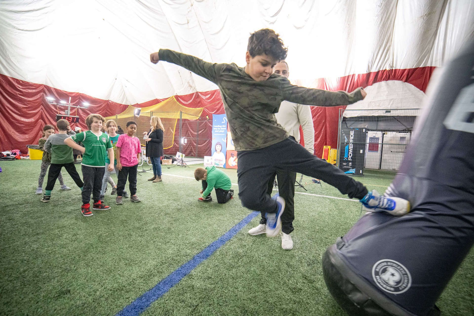 A young boy is kicking a soccer ball on a field.