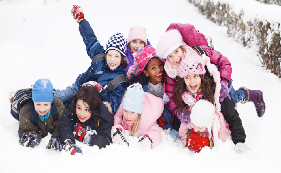a group of children are laying in the snow together