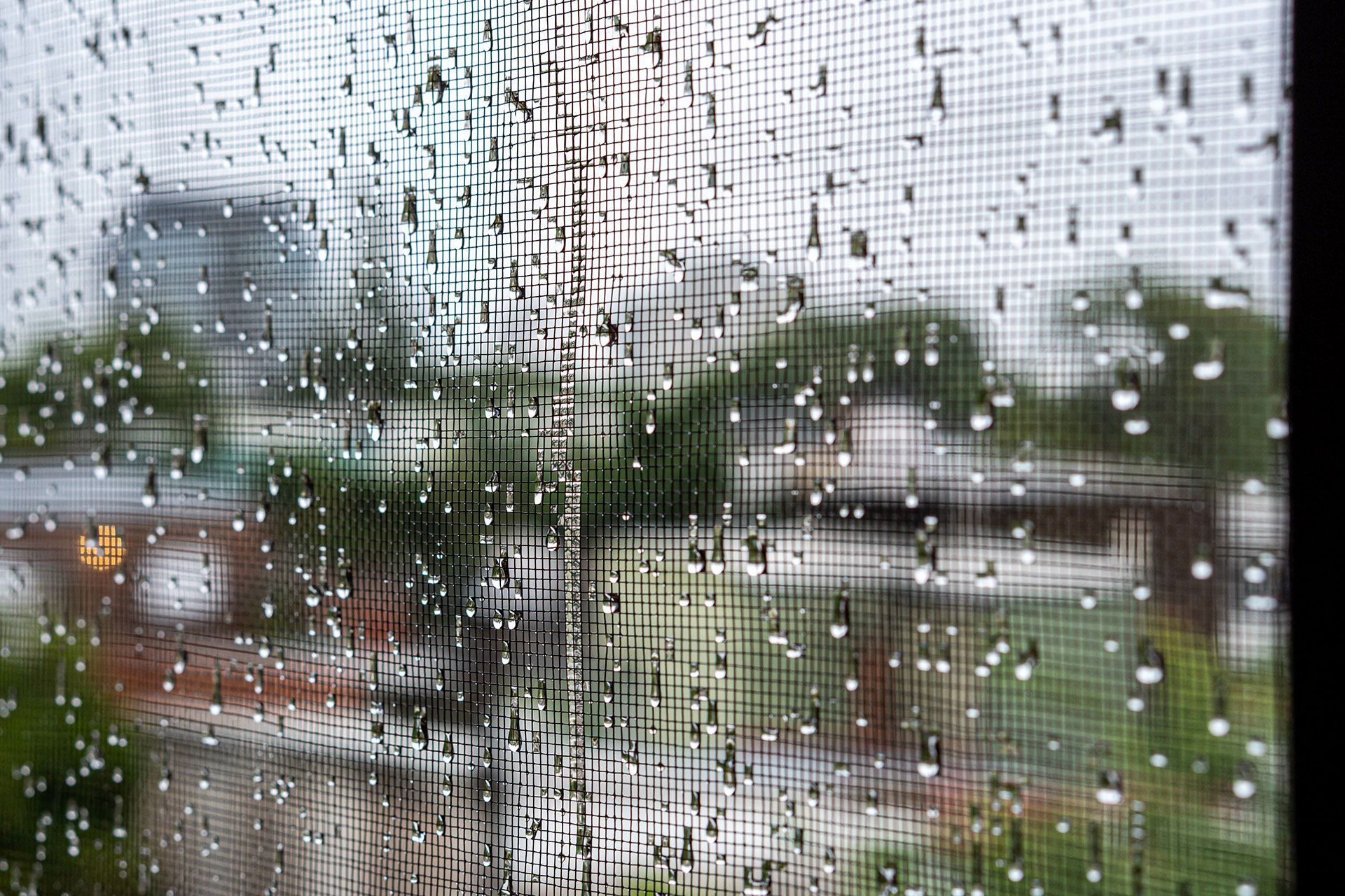 A window with rain drops on it and a view of a city.