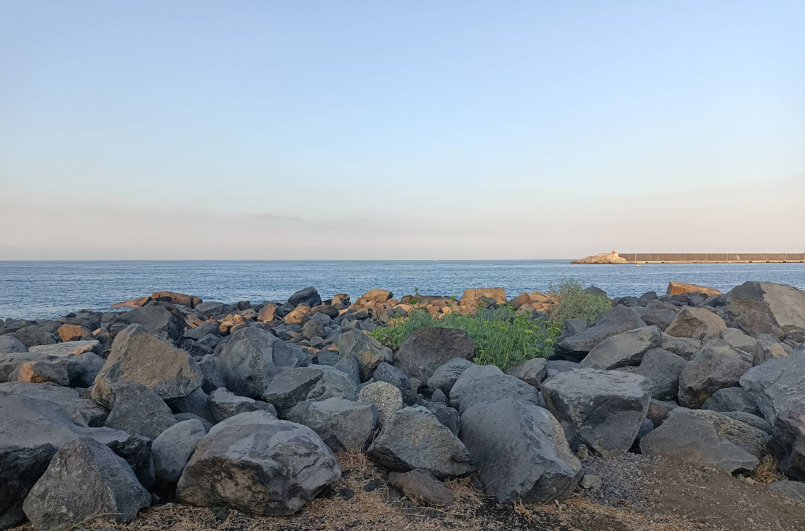 Costa rocciosa con oceano e cielo terso.