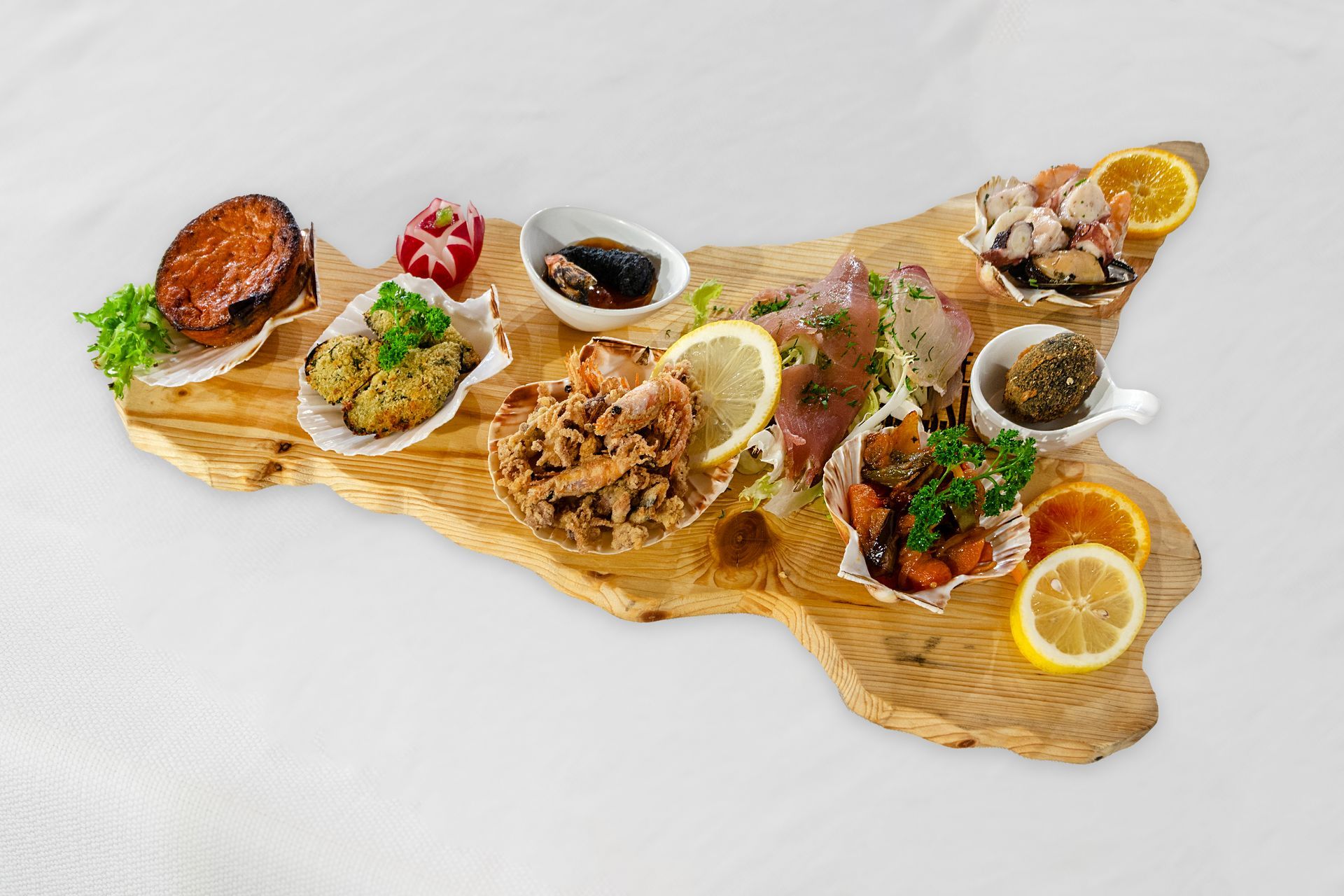 Antipasti di mare disposti su un tagliere di legno a forma di Sicilia; varie preparazioni con fettine di limone e arancia.