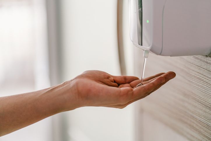 Asian woman hand using wash hand sanitizer gel dispenser