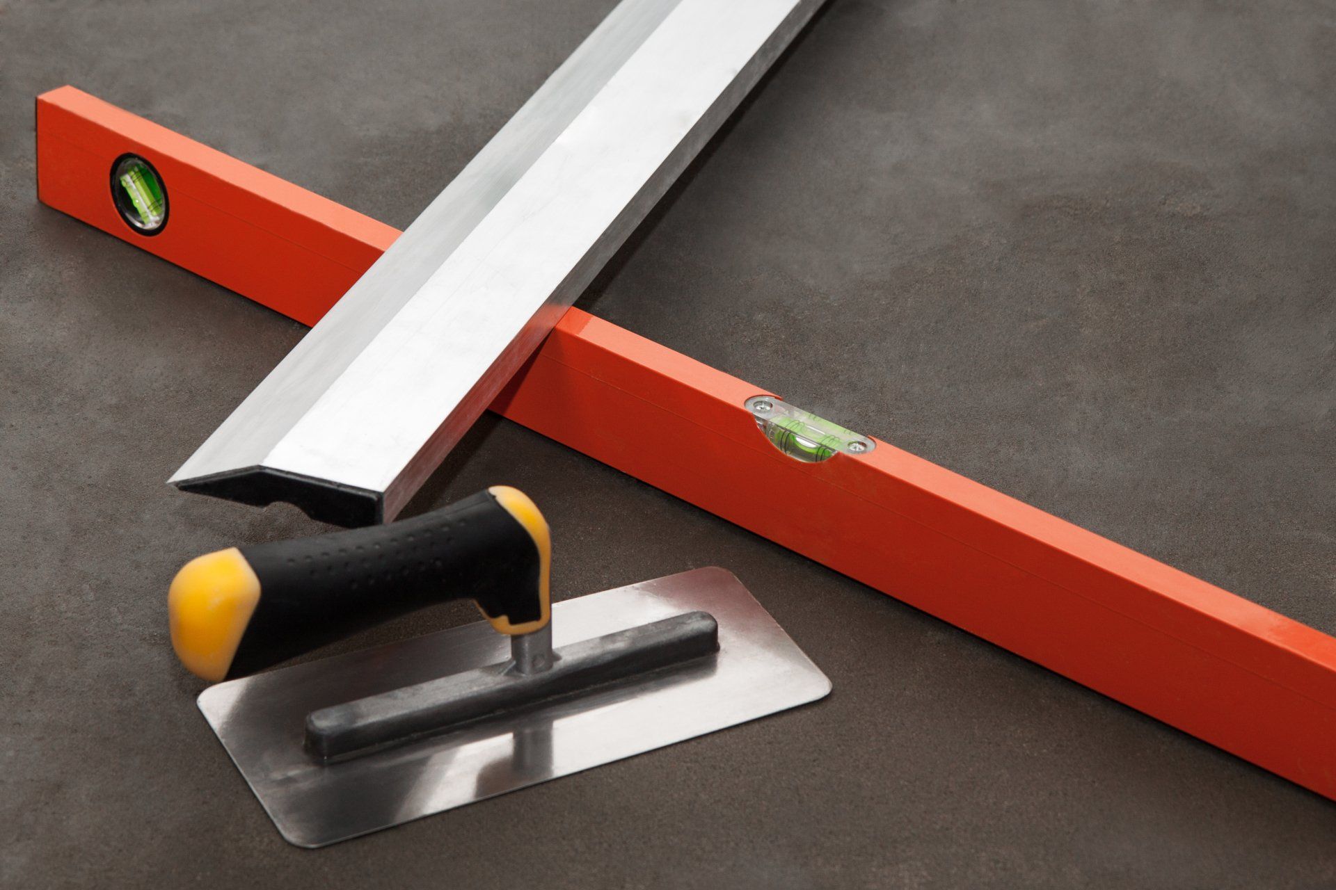 A trowel and a level are on a table
