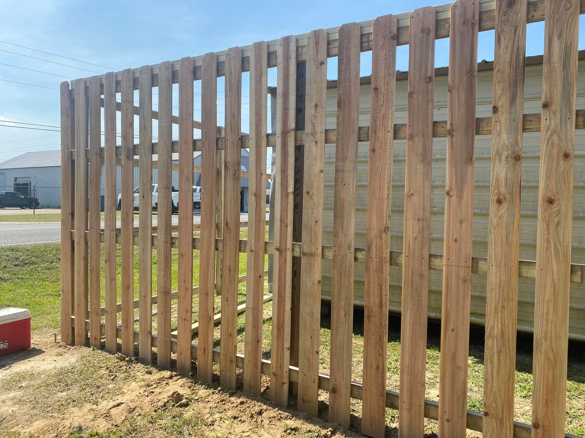 Wooden fence with vertical slats, outdoors on a sunny day.