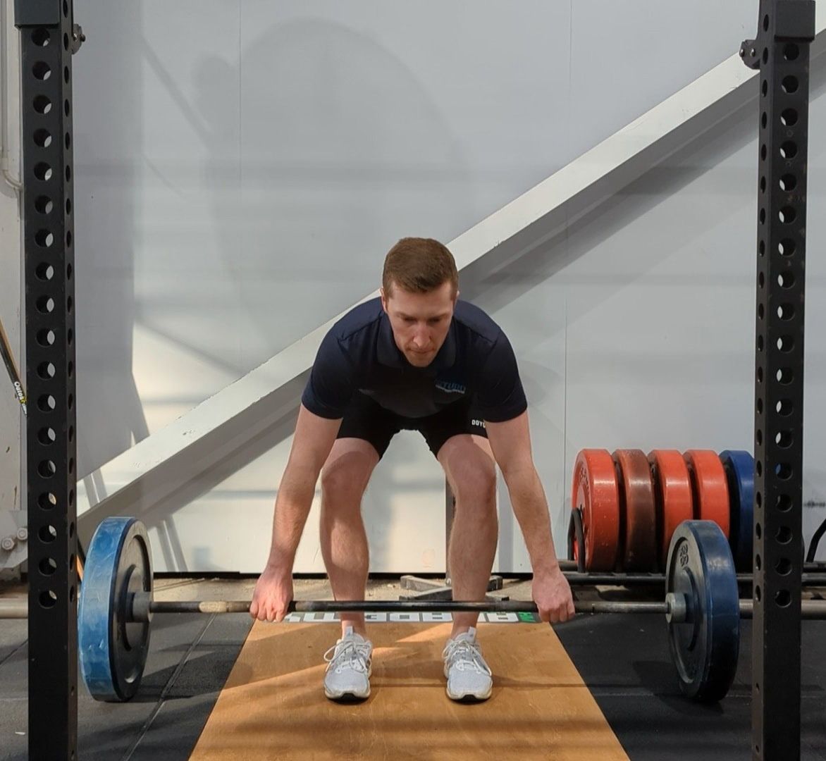 Individual Performing a Barbell Lift While in a Squatting Position — Return to Performance Physiotherapy In Epsom, VIC