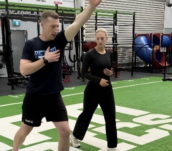 A Man Demonstrating an Arm Exercise in a Gym — Return to Performance Physiotherapy in Epsom, VIC