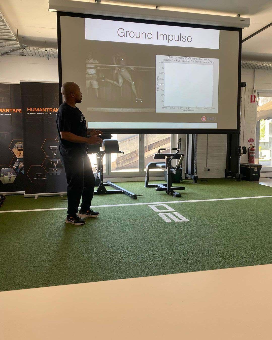 Man is Giving a Presentation in Front of a Large Screen in a Gym — Return to Performance Physiotherapy in Epsom, VIC