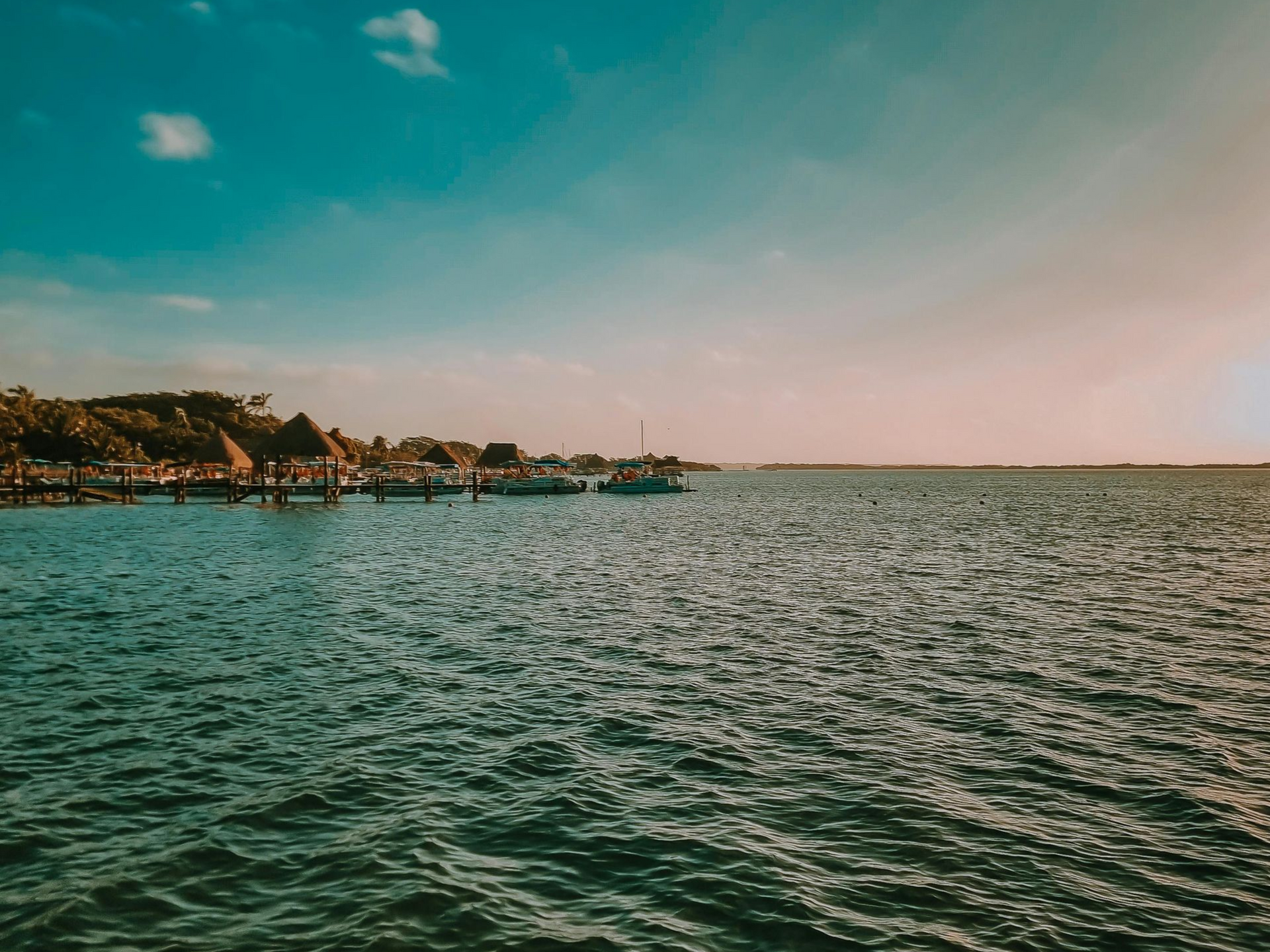 Aguas costeras tranquilas junto a una costa rocosa bajo un cielo azul despejado.