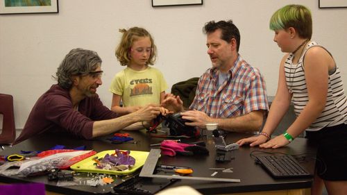 A family enjoys hands-on activities at a STEAM Social event at ScienceWorks