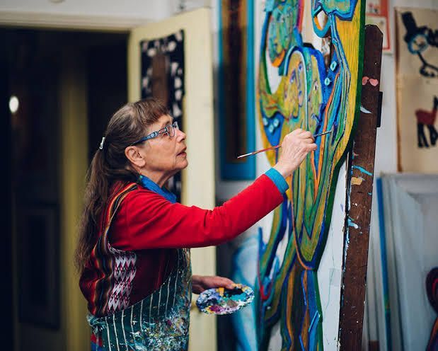 Artist Betty LaDuke painting in her studio
