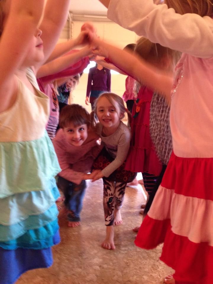 young children dancing under a bridge of other children holding hands