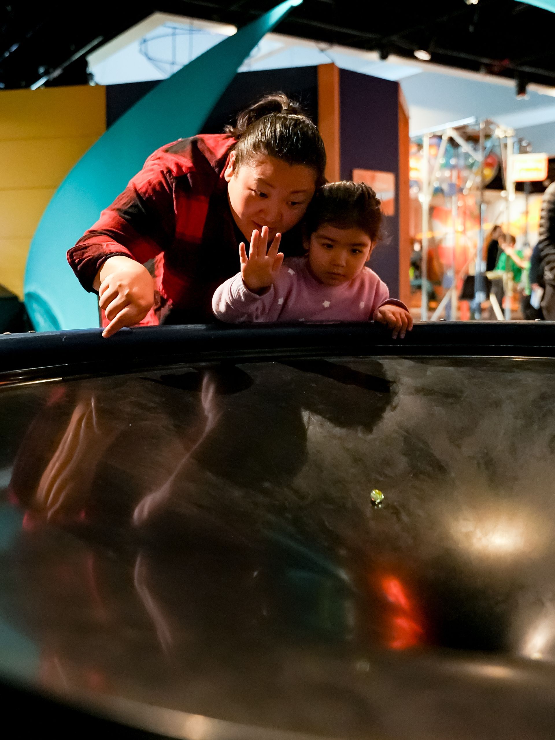 Woman and child looking into a display about gravity  at ScienceWorks.