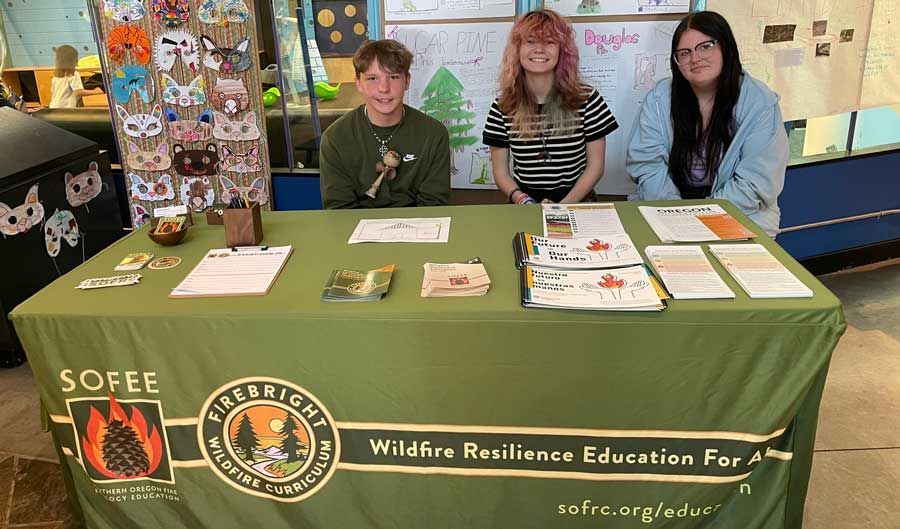 Young teen students showing their wildfire ecology projects at ScienceWorks during the Sparking Action event.
