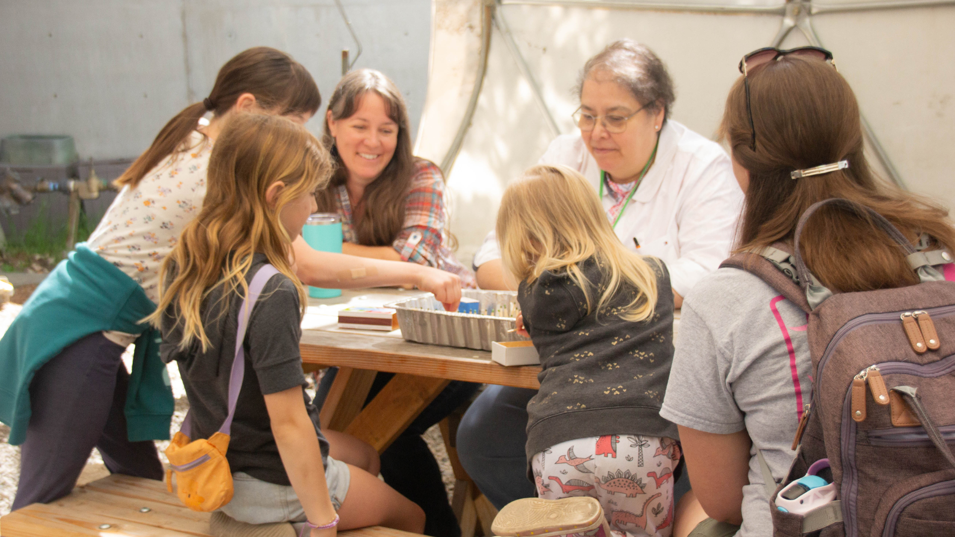 Photo of ScienceWorks staff leading a wild fire ecology lesson with 2 adults and 3 kids